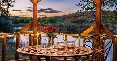 Romantic gazebo at the pond with toasting glasses for two