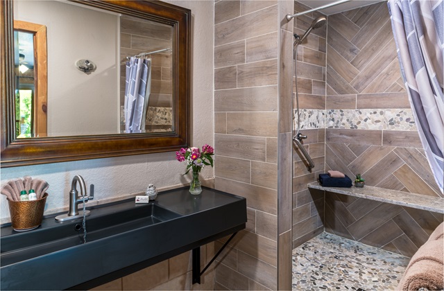 5x5 walkin shower with bench and triple shower head in Whispering Pines room at Three Falls Cove